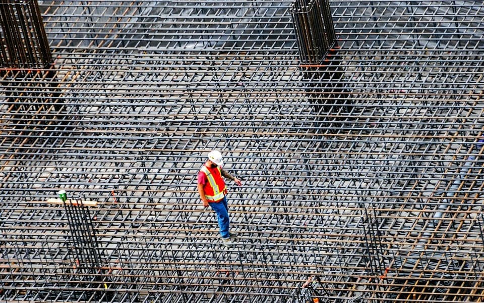 An engineer inspecting steel reinforcement on a construction site
